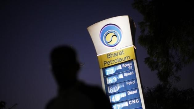 A Bharat Petroleum oil pump station displays the price of unleaded petrol and Diesel as a pedestrian walks past in New Delhi.(Reuters)