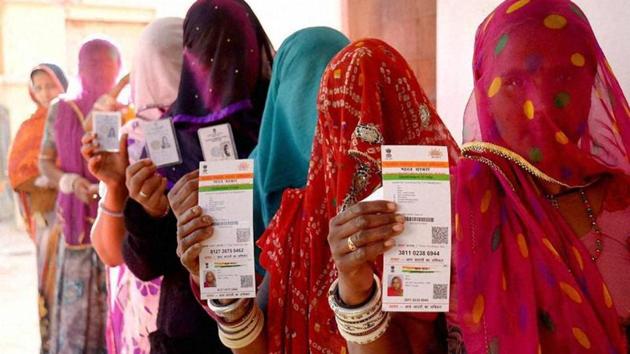 Rajasthani women showing their respective Aadhaar cards while standing in a queue to vote for Ajmer District Panchayat elections.(PTI Photo)
