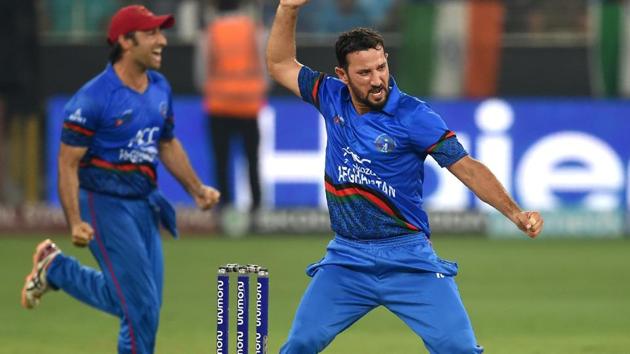 Afghan cricketer Javed Ahmadi (R) celebrates after he dismissed unseen Indian batsman MS Dhoni during the one day international (ODI) Asia Cup cricket match between Afghanistan and India at the Dubai International Cricket Stadium in Dubai on September 25, 2018. (Photo by ISHARA S. KODIKARA / AFP) (AFP)
