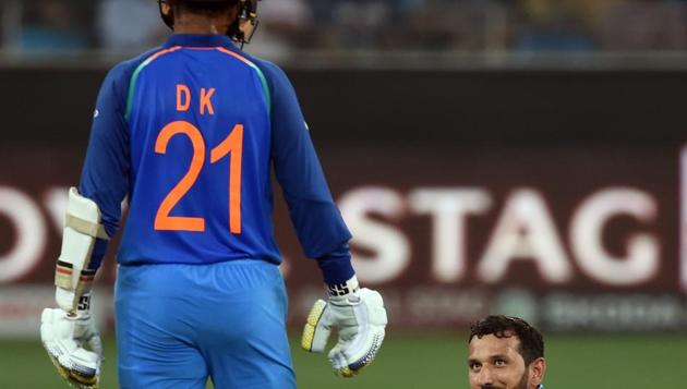 Afghan cricketer Javed Ahmadi (R) reacts as he holds the bat of Indian batsman Dinesh Karthik after they collided with each other during the one day international (ODI) Asia Cup cricket match between Afghanistan and India at the Dubai International Cricket Stadium in Dubai on September 25, 2018. (Photo by ISHARA S. KODIKARA / AFP) (AFP)