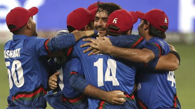 Afghanistan players congratulate teammate Rashid Khan, center without cap, after he dismissed India's Ravindra Jadeja during the one day international cricket match of Asia Cup between India and Afghanistan in Dubai. (AP)