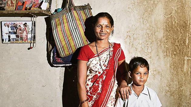 Ranjana Sonawane stands near a photo of her getting an Aadhaar number, in Maharashtra’s Tembhli village. (Kunal Patil/HT Archive) Ranjana Sonawane stands near a photo of her getting an Aadhaar number, in Maharashtra’s Tembhli village. (Kunal Patil/HT Archive)