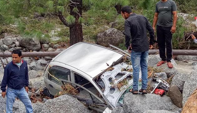Locals inspect a damaged car washed ashore due to incessant rains, at Palampur approximately 45km from Dharamshala, Monday, Sept 24, 2018. (PTI) Locals inspect a damaged car washed ashore due to incessant rains, at Palampur approximately 45km from Dharamshala, Monday, Sept 24, 2018. (PTI)