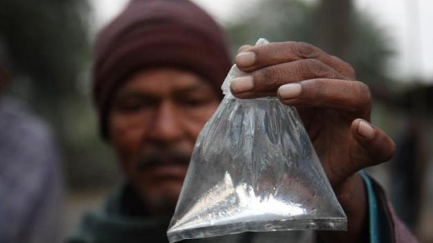 A villager of Enayatpur of Magrahat showing a packet of 'Hooch Pouch' at Magrahat in West Bengal on December 15, 2011. A court in Bengal Thursday convicted four people in the toxic liquor case that killed 172 persons in South Parganas’s Sangrampur village in December 2011 and left several others blind. (Representative Image/HT File Photo) A villager of Enayatpur of Magrahat showing a packet of 'Hooch Pouch' at Magrahat in West Bengal on December 15, 2011. A court in Bengal Thursday convicted four people in the toxic liquor case that killed 172 persons in South Parganas’s Sangrampur village in December 2011 and left several others blind. (Representative Image/HT File Photo)