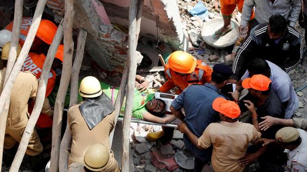 Rescuers carry a survivor amidst the rubble after a building collapsed in New Delhi, India, September 26, 2018.(REUTERS) Rescuers carry a survivor amidst the rubble after a building collapsed in New Delhi, India, September 26, 2018.(REUTERS)