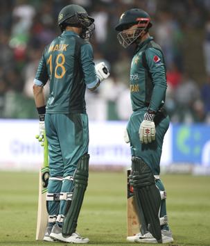 Pakistan's Shoaib Malik, left, gives some tips to teammate Shadab Khan as he leaves the ground after losing his wicket. (AP)