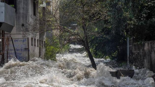 Water floods the residential area near Dandekar bridge after the canal wall was breached on Thursday morning. (HT Photo) Water floods the residential area near Dandekar bridge after the canal wall was breached on Thursday morning. (HT Photo)