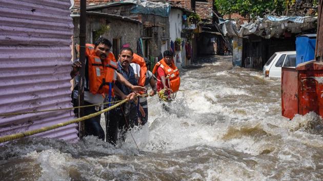 On arrival, fire brigade officials used ropes and human chains to rescue around 100-150 people from the locality. People who had gone out to work rushed back home on receiving news of the floods. However, they were not allowed to reach their homes by the police as water continued to be discharged with force. (SANKET WANKHADE/HT PHOTO) On arrival, fire brigade officials used ropes and human chains to rescue around 100-150 people from the locality. People who had gone out to work rushed back home on receiving news of the floods. However, they were not allowed to reach their homes by the police as water continued to be discharged with force. (SANKET WANKHADE/HT PHOTO)