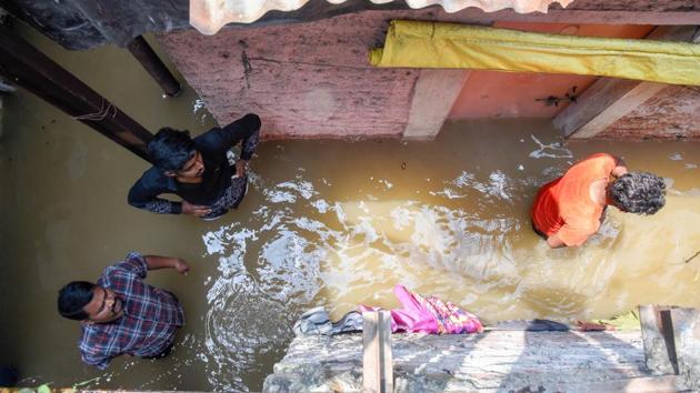 Residents of slum wade through waist-deep water after the area near Dandekar bridge was flooded due to the collapse of Mutha canal wall on Thursday. (SANKET WANKHADE/HT PHOTO) Residents of slum wade through waist-deep water after the area near Dandekar bridge was flooded due to the collapse of Mutha canal wall on Thursday. (SANKET WANKHADE/HT PHOTO)
