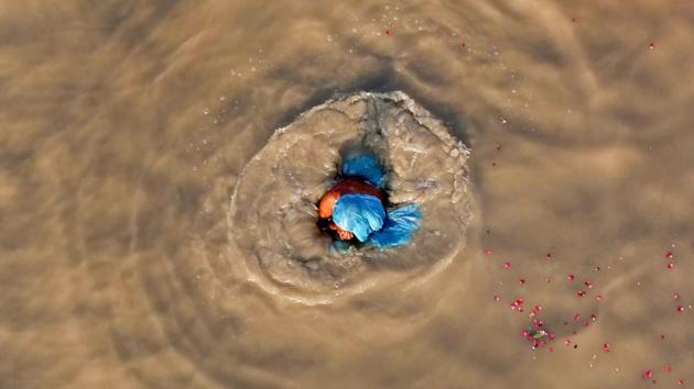 A woman takes a dip in the muddy water of the river Ganga, in Allahabad, Uttar Pradesh. (PTI)