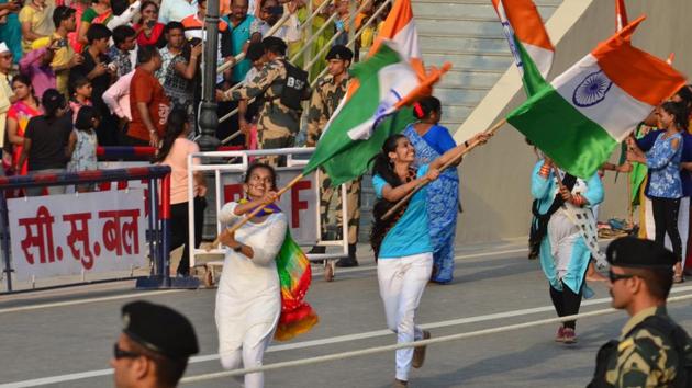Before the actual ceremony begins, women and children can be seen dancing to patriotic Bollywood songs at the border. (Sameer Sehgal/ht) Before the actual ceremony begins, women and children can be seen dancing to patriotic Bollywood songs at the border. (Sameer Sehgal/ht)