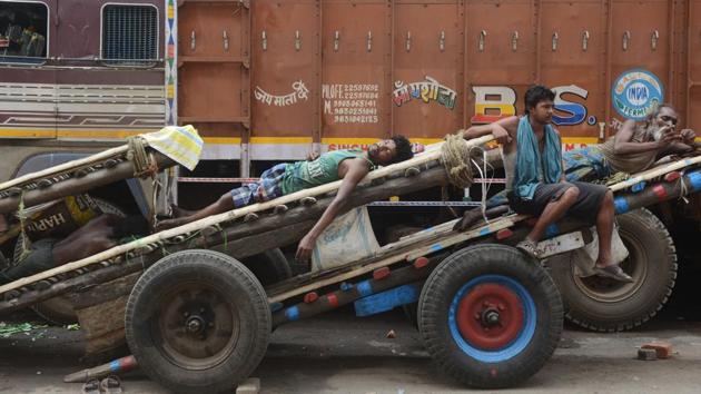 Labourers rest on their hand-pulled-carts by a roadside during a 12-hour long statewide strike ‘Bangla Bandh’ called by the Bharatiya Janata Party to protest against the killings of two students in Kolkata, West Bengal. (Dibyangshu Sarkar / AFP)
