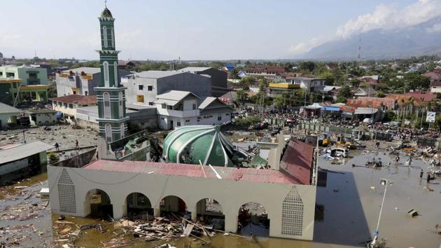 People survey a mosque damaged during a earthquake and a tsunami in Palu, Indonesia. The death toll, which has more than doubled from Sunday morning, is expected to climb higher still, with heavily populated areas outside the city still cut off from any assistance, and desperate search-and-rescue efforts continuing in the rubble of Palu, often with only rudimentary tools. (Tatan Syuflana / AP) People survey a mosque damaged during a earthquake and a tsunami in Palu, Indonesia. The death toll, which has more than doubled from Sunday morning, is expected to climb higher still, with heavily populated areas outside the city still cut off from any assistance, and desperate search-and-rescue efforts continuing in the rubble of Palu, often with only rudimentary tools. (Tatan Syuflana / AP)