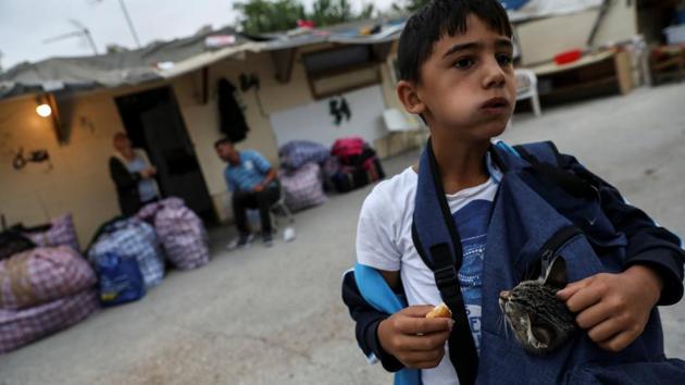 David Stan, 7, tries to hide his cat Coral in his backpack as he waits to move out. David and Beatriz’s parents arrived from Țăndărei, Romania, 17 years ago and had lived in the Gallinero for most of their time since. “She’s scared someone will take us,” Beatriz said. (Susana Vera / REUTERS) 