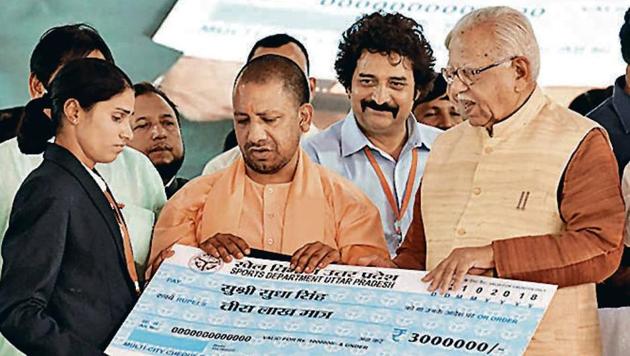 Asian Games gold medallist Sudha Singh with UP chief minister Yogi Adityanath and governor Ram Naik.(HT Photo)