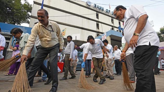 Staff members of the Bank of Maharashtra participate in a cleanliness drive on the eve of Gandhi Jayanti in Pune on Monday. (Pratham Gokhale/HT Photo)