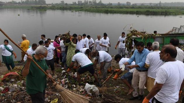 Residents of east Delhi along with BJP workers and its youth wing members cleaning up the Yamuna river.(HT Photo)