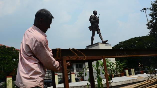 A worker is seen making a pandal ahead of Gandhi Jayanti, near Pune railway station, on Monday. (SHANKAR NARAYAN/HT PHOTO)