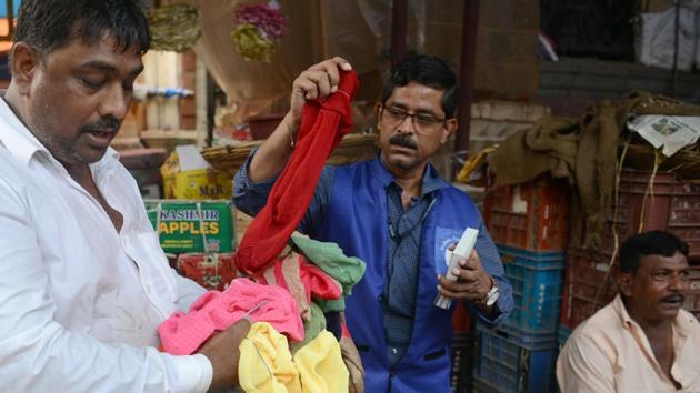 A shopkeeper (L) holds cloth bags while a city civic officer (C) checks them. A walk through Crawford Market and visits to grocery stores and food stalls suggest many traders have switched to cloth bags and paper straws. But others continue to violate the ban and large piles of plastic items can still be seen on the city’s beaches and streets. (Punit Paranjpe / AFP) A shopkeeper (L) holds cloth bags while a city civic officer (C) checks them. A walk through Crawford Market and visits to grocery stores and food stalls suggest many traders have switched to cloth bags and paper straws. But others continue to violate the ban and large piles of plastic items can still be seen on the city’s beaches and streets. (Punit Paranjpe / AFP)