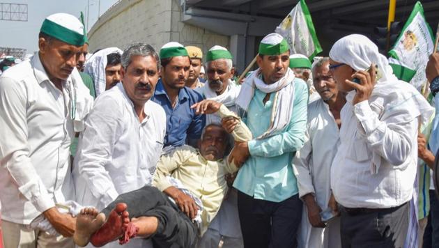 An injured farmer being carried by other protesters during 'Kisan Kranti Padyatra' at Delhi-UP border in New Delhi, Oct 2, 2018.(PTI)