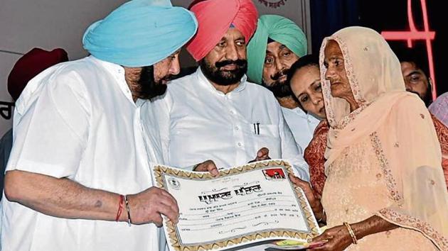 Chief minister Captain Amarinder Singh handing over a certificate to a government scheme beneficiary in Mohali on Tuesday. (HT Photo) Chief minister Captain Amarinder Singh handing over a certificate to a government scheme beneficiary in Mohali on Tuesday. (HT Photo)