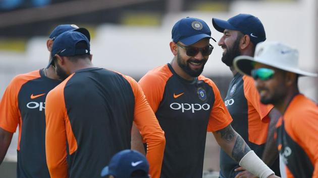 Indian cricket captain Virat Kohli (C) jokes with teammates as he arrives for a training session ahead of the first Test cricket match between India and West Indies at the Saurashtra Cricket Association stadium in Rajkot(AFP)