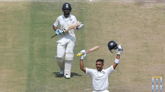 Indian cricketer Cheteshwar Pujara (top) applauds as teammate Prithvi Shaw celebrates after his maiden century (100 runs) during the first play of the first Test cricket match between India and West Indies at the Saurashtra Cricket Association stadium in Rajkot. (AFP) Indian cricketer Cheteshwar Pujara (top) applauds as teammate Prithvi Shaw celebrates after his maiden century (100 runs) during the first play of the first Test cricket match between India and West Indies at the Saurashtra Cricket Association stadium in Rajkot. (AFP)