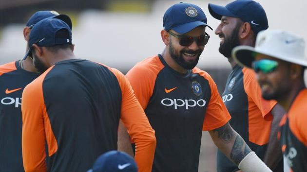 Indian cricket captain Virat Kohli (C) jokes with teammates as he arrives for a training session. (AFP)