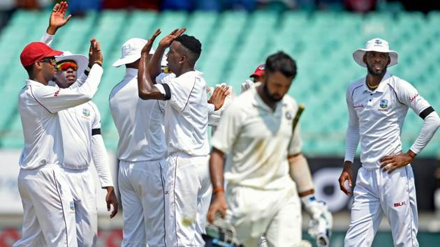 West Indies bowler Sherman Lewis celebrates the dismissal of Indian batsman Cheteshwar Pujara on day one of the first test cricket match against West Indies, in Rajkot. Virat Kohli scored a brilliant half century and his partnership with Ajinkya Rahane has taken India’s score beyond 300 on the day one of the test match. (PTI)