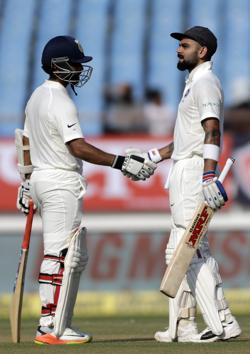 India's Virat Kohli, right, celebrates his fifty during the first day of the first cricket test match between India and West Indies in Rajkot. (AP) India's Virat Kohli, right, celebrates his fifty during the first day of the first cricket test match between India and West Indies in Rajkot. (AP)