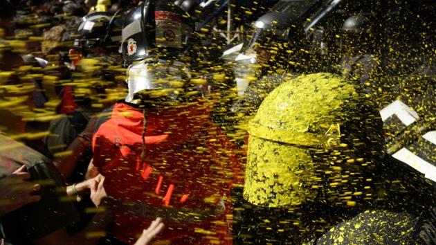 Pro independence demonstrators throw paint at Catalan police officers during clashes in Barcelona, Spain. (Daniel Cole / AP) Pro independence demonstrators throw paint at Catalan police officers during clashes in Barcelona, Spain. (Daniel Cole / AP)