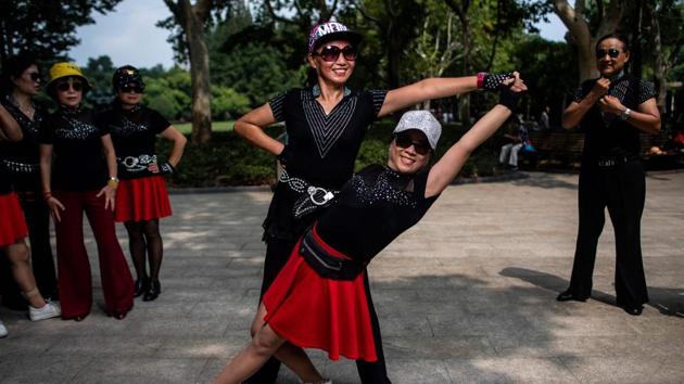 Two women from a square dancing team striking a pose for a photograph in a public park in Shanghai. (AFP) Two women from a square dancing team striking a pose for a photograph in a public park in Shanghai. (AFP)
