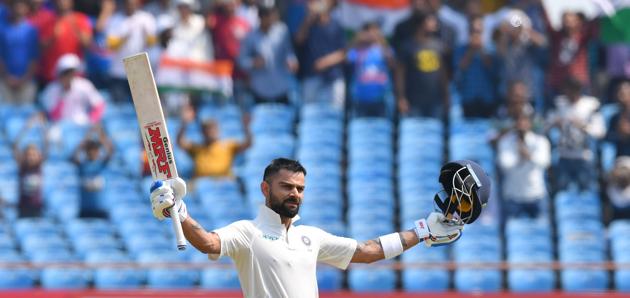Indian cricket captain Virat Kohli celebrates after reaching his century (100 runs) during the second day's play of the first Test cricket match between India and West Indies at the Saurashtra Cricket Association stadium in Rajkot. (AFP)