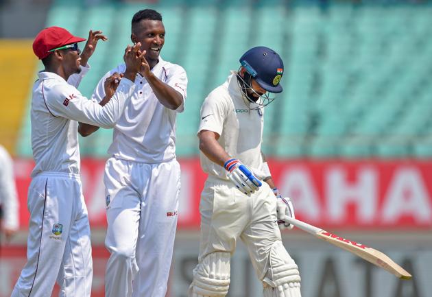 Rajkot: West Indies bowler Sherman Lewis (C) celebrates the wicket of Indian batsman Virat Kohli (R) during the test cricket match played between India and West Indies in Rajkot. (PTI)