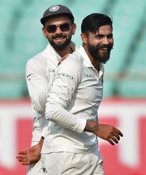 Rajkot: Indian bowler Ravindra Jadeja (R) celebrates the wicket of West Indies batsman Sunil Ambris as team captain Virat Kohli looks on, during their first test cricket match in Rajkot. (PTI)