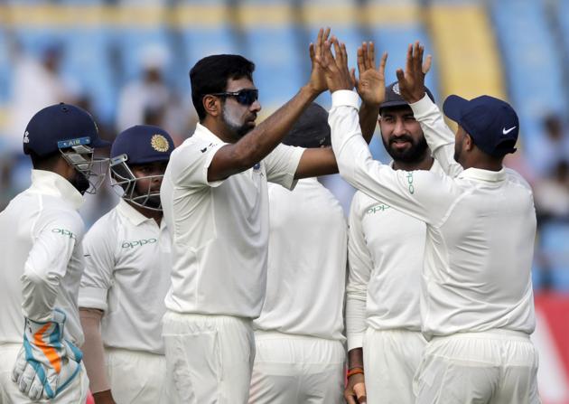 Indian cricketer Ravichandran Ashwin, without cap, celebrates with teammates after dismissing West Indies' Shai Hope during the second day of the first cricket test match between India and West Indies in Rajkot. (AP)
