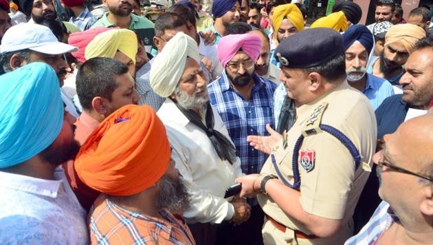 Congress councilor Ajit Singh Bhatia with party workers and shopkeepers talking with police officials during protest near Partition museum at heritage street in Amritsar. (Sameer Sehgal/HT) Congress councilor Ajit Singh Bhatia with party workers and shopkeepers talking with police officials during protest near Partition museum at heritage street in Amritsar. (Sameer Sehgal/HT)