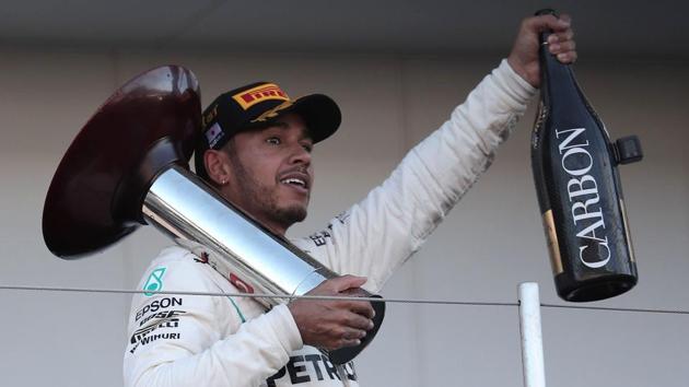 Lewis Hamilton celebrates on the podium after his victory in the Formula One Japanese Grand Prix at Suzuka.(AFP)