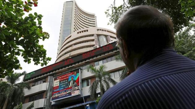 A man looks at a screen across a road displaying the Sensex on the facade of the Bombay Stock Exchange (BSE) building in Mumbai.(REUTERS)