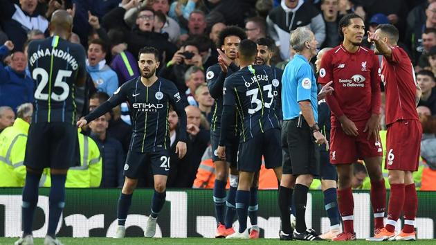 Manchester City's Portuguese midfielder Bernardo Silva (2L), Manchester City's German midfielder Leroy Sane (3L), Manchester City's Brazilian striker Gabriel Jesus (4L) talk with Manchester City's Algerian midfielder Riyad Mahrez (4R) as English referee Martin Atkinson (3R) talks with Liverpool's Dutch defender Virgil van Dijk (2R) and awards Manchester City a penalty.(AFP)