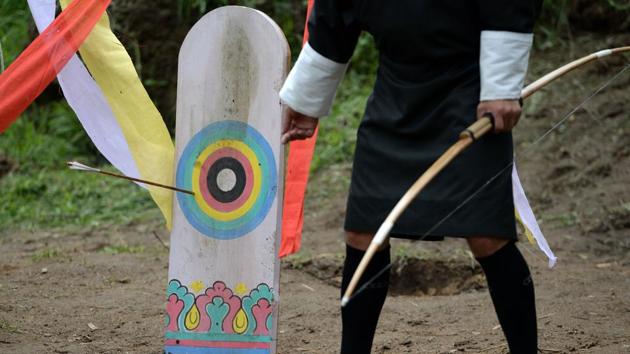 A Bhutanese archer points to a target hit by an arrow. “We drink to gain confidence. We have a belief that if we drink we can hit the target better,” the 25-year-old said, barely hiding a sheepish grin. The game they play pits two teams of 11 players each who try to hit the maximum number of bull’s-eyes on a fixed target a full 140 metres away. (Arun Sankar / AFP) 