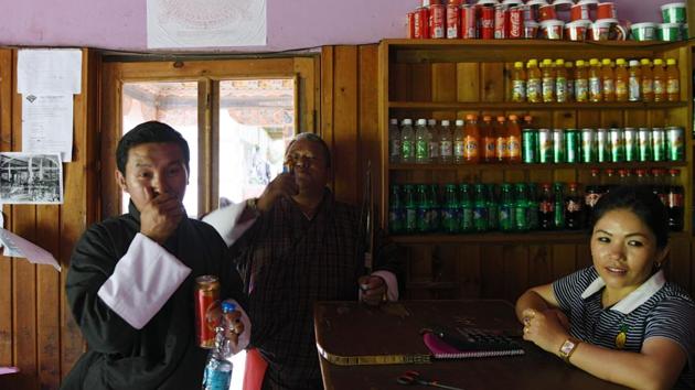 An archer (L) drinks a local alcoholic brew at the Changlimithang Archery Ground in Thimphu. Archery was popularised by the first king of Bhutan Gongsa Ugyen Wangchuk (1862-1926) and flourished under royal patronage. But it suffered a decline after the nation decided to pursue economic development and open its doors to modernisation, eventually allowing in television in 1999. (Arun Sankar / AFP) 