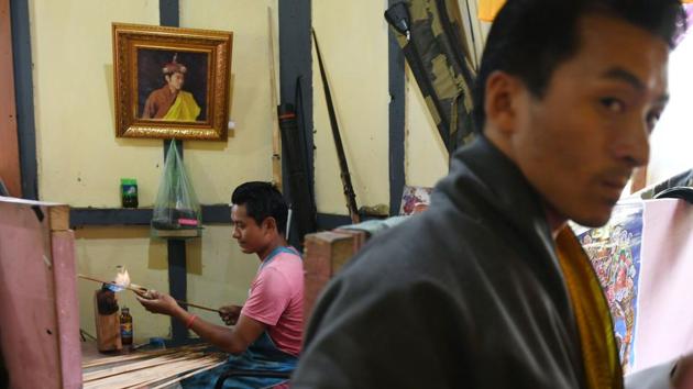 A Bhutanese arrow maker (L) heats a bamboo stick as he makes an arrow. The advent of more advanced compound and recurve archery has meant Bhutanese archers used to traditional equipment made of bamboo reeds have struggled to find their feet in international competitions. Bhutan has sent archers to every Olympics since 1984 but a medal has eluded the nation. (Arun Sankar / AFP) 