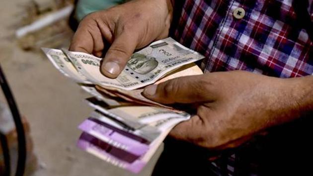 A customer counts rupee notes at a fuel station.(PTI Photo)