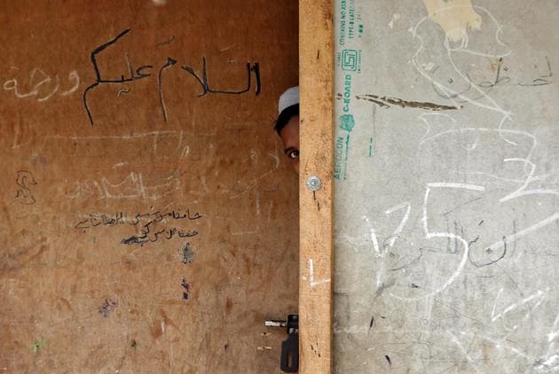 A Rohingya boy peeks out from behind the door of a madrasa, or a religious school, at a camp on the outskirts of Jammu. More than 700,000 Rohingya, according to UN agencies, have escaped Rakhine to neighbouring Bangladesh over the past year, bringing accounts of mass killings, arson, and rapes by the Myanmar army. An estimated 40,000 Rohingya, a largely stateless Muslim minority, live in India. (Mukesh Gupta / REUTERS) A Rohingya boy peeks out from behind the door of a madrasa, or a religious school, at a camp on the outskirts of Jammu. More than 700,000 Rohingya, according to UN agencies, have escaped Rakhine to neighbouring Bangladesh over the past year, bringing accounts of mass killings, arson, and rapes by the Myanmar army. An estimated 40,000 Rohingya, a largely stateless Muslim minority, live in India. (Mukesh Gupta / REUTERS)