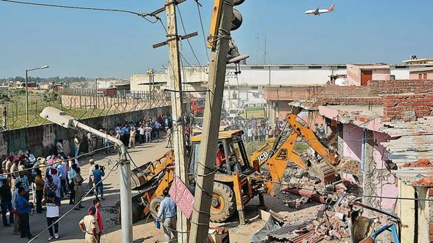 The demolition drive going on in Pabhat village in Zirakpur near Chandigarh International Airport on Monday. Two JCBs, a fire tender, an ambulance and a hydraulic machine were pressed into service by the authorities. (HT Photo) The demolition drive going on in Pabhat village in Zirakpur near Chandigarh International Airport on Monday. Two JCBs, a fire tender, an ambulance and a hydraulic machine were pressed into service by the authorities. (HT Photo)