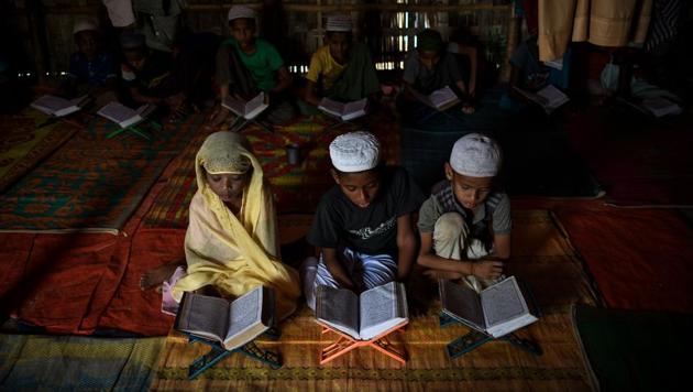 Saleema Khanam (L), studies inside a makeshift madrassa with other students in Kutupalong camp, near Cox's Bazar. She takes her position in the front, flanked by two brothers, and opens the book. “I come here to learn the Quran. My mother wants me and my brothers to learn, to become better people,” the young student told AFP. (Chandan Khanna / AFP) Saleema Khanam (L), studies inside a makeshift madrassa with other students in Kutupalong camp, near Cox's Bazar. She takes her position in the front, flanked by two brothers, and opens the book. “I come here to learn the Quran. My mother wants me and my brothers to learn, to become better people,” the young student told AFP. (Chandan Khanna / AFP)