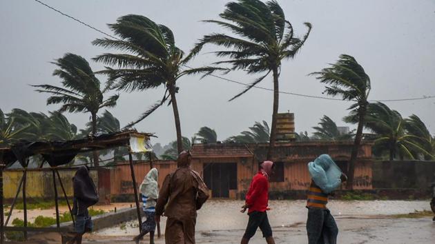 People make their way as Cyclone Titli makes landfall, starting with surface winds reaching speeds of 126 kmph at Gopalpur, in Odisha. Officials on Wednesday said that more than 300,000 people have been evacuated, operations suspended at the port of Paradip and many trains and flights cancelled. Eight people have died in Srikakulam and Vijayanagaram districts, reports ANI. (PTI)