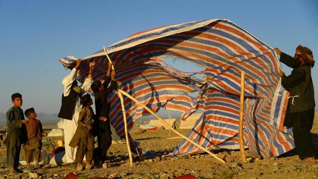 A tent is erected at a camp in Injil. Conditions are miserable in the camps that have mushroomed across the unforgiving landscape in recent months as above-average temperatures and intense fighting forced more people to abandon their villages and livelihoods. (Hoshang Hashimi / AFP) A tent is erected at a camp in Injil. Conditions are miserable in the camps that have mushroomed across the unforgiving landscape in recent months as above-average temperatures and intense fighting forced more people to abandon their villages and livelihoods. (Hoshang Hashimi / AFP)