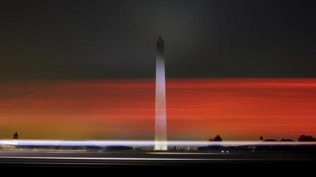 Early morning traffic streaks past the Washington Monument before daybreak. (J. David Ake / AP)